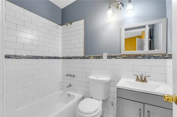 a bathroom with a granite countertop sink a mirror and a bathtub