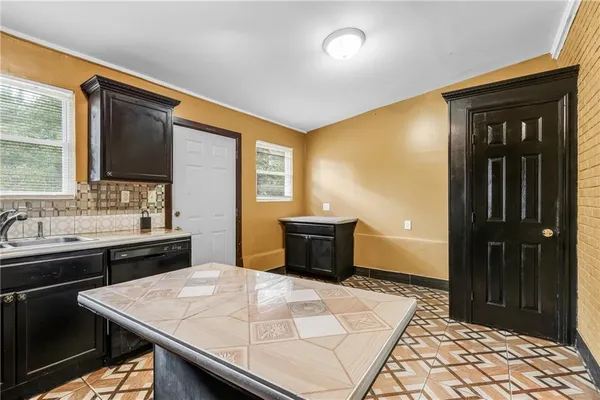 a kitchen with a sink a stove top oven a counter space and cabinets