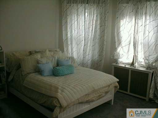 356 New Market Road Dunellen, NJ 08812 - Photo 7 of 8 a large bed sitting in a bedroom next to a window