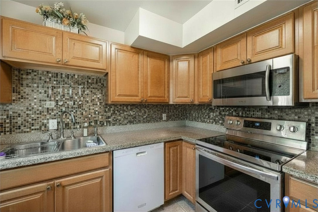 9217 Fisk Road Richmond, VA 23229 - Photo 13 of 39 a kitchen with stainless steel appliances granite countertop a sink stove and microwave