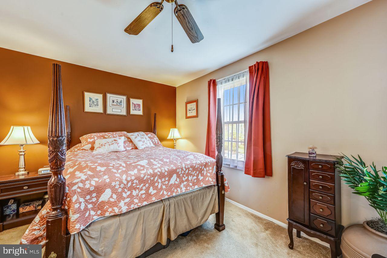 355 Rambling Ridge Court Pasadena, MD 21122 - Photo 15 of 28 a bedroom with a bed and a chandelier