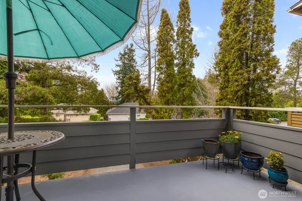 a view of a roof deck with table and chairs under an umbrella
