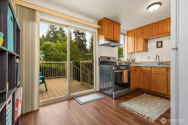 a kitchen with stainless steel appliances granite countertop a refrigerator a sink and wooden cabinets