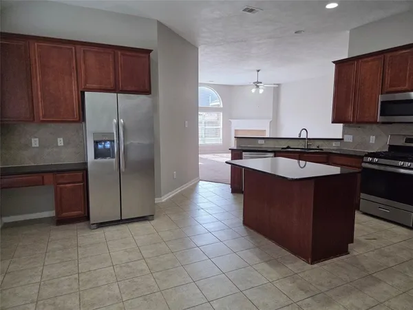 a kitchen with stainless steel appliances granite countertop a stove a refrigerator and a sink