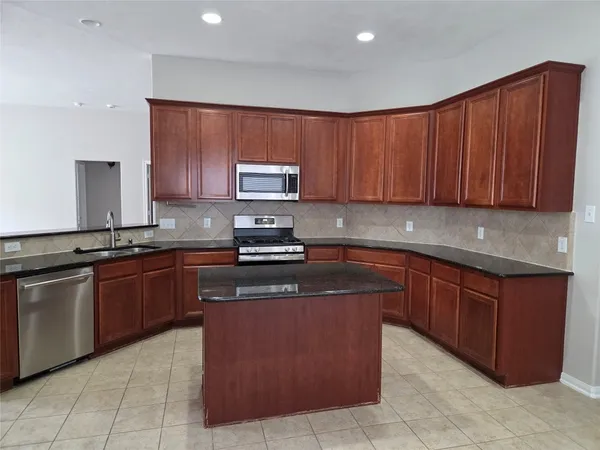 a kitchen with stainless steel appliances granite countertop a stove sink and cabinets