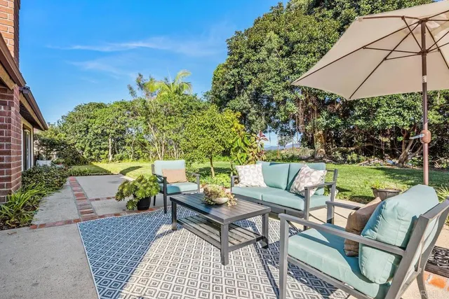 a view of a patio with couches under an umbrella