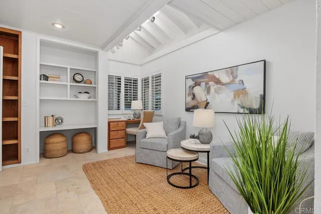 a living room with furniture a rug and white walls