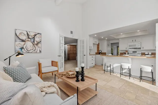 a living room with furniture kitchen view and a table