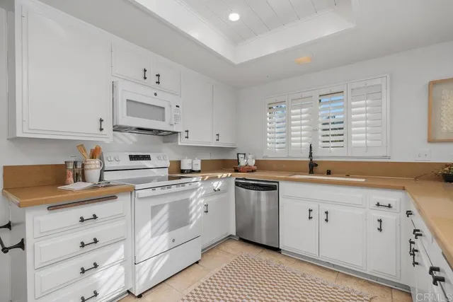 a kitchen with cabinets appliances a sink and a window