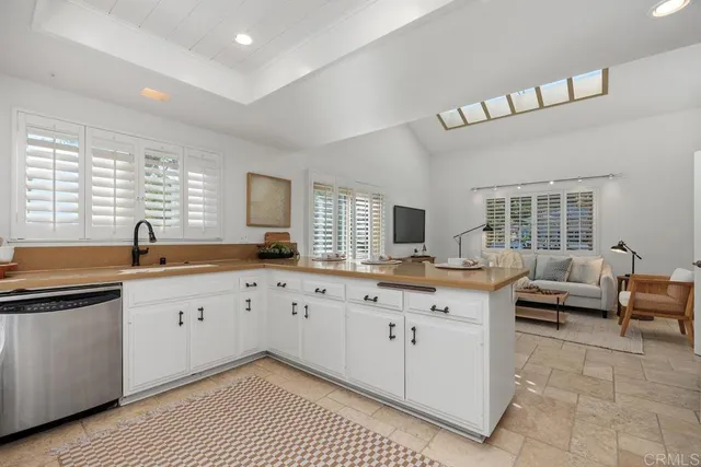 a kitchen with granite countertop a sink white cabinets and wooden floor