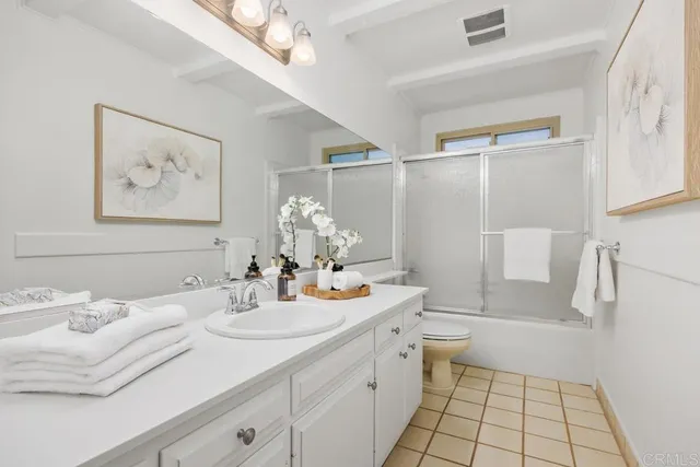 a bathroom with a toilet and a potted plant
