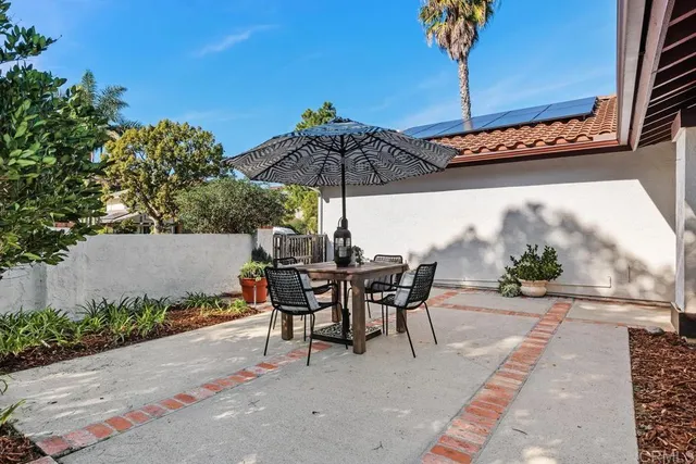 a view of a patio with a table and chairs under an umbrella