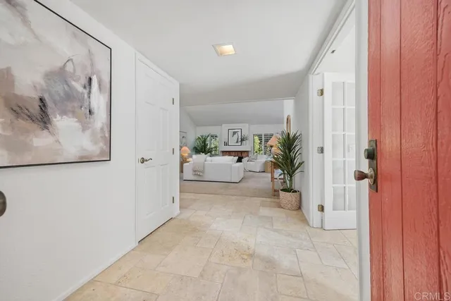 a view of a hallway and a livingroom with furniture