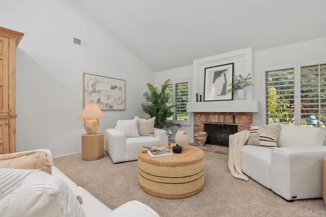 a living room with furniture a fireplace and a large window