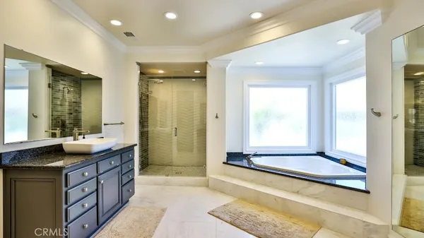 a bathroom with a tub a sink and a mirror