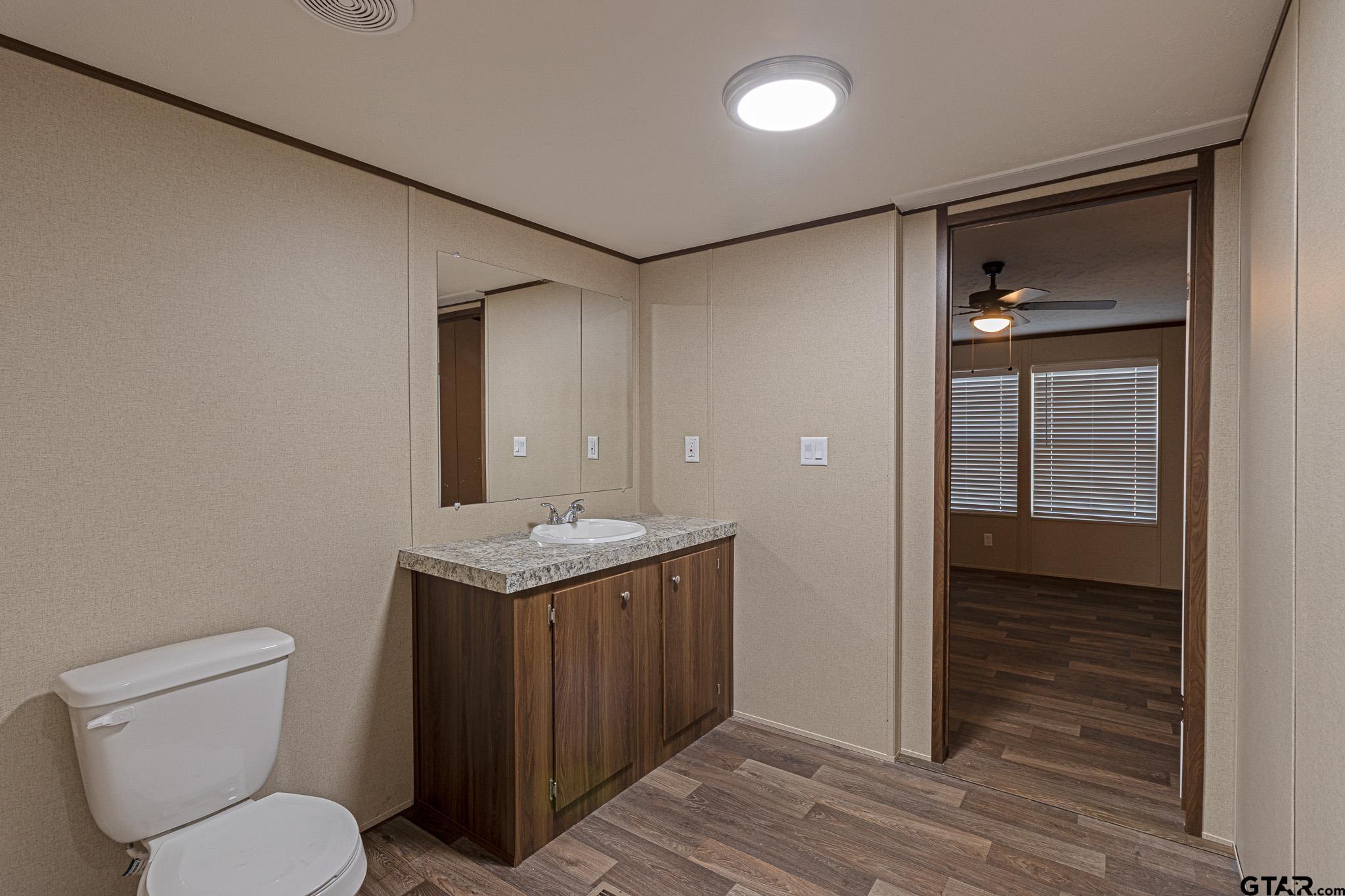 9806 FM 773 Murchison, TX 75778 - Photo 20 of 35 a bathroom with a granite countertop sink toilet and shower