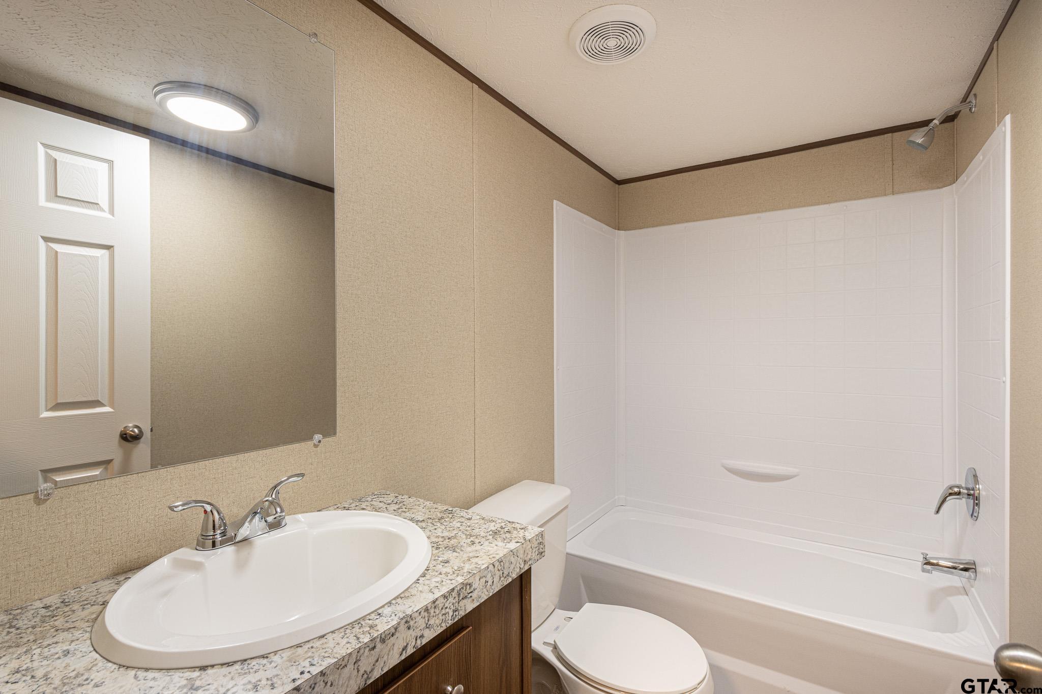 9806 FM 773 Murchison, TX 75778 - Photo 24 of 35 a bathroom with a granite countertop sink toilet and shower