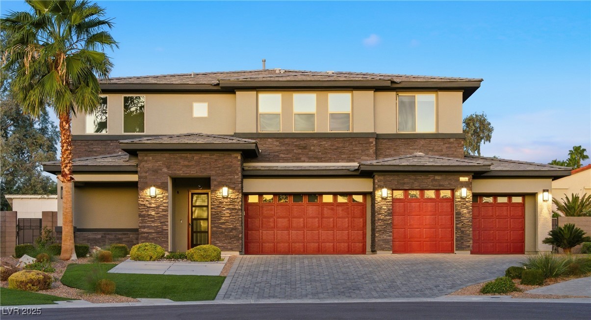 7736 Tioga Ridge Las Vegas, NV 89117 - Photo 1 of 68 Prairie-style house with stucco siding, decorative driveway, stone siding, and an attached garage