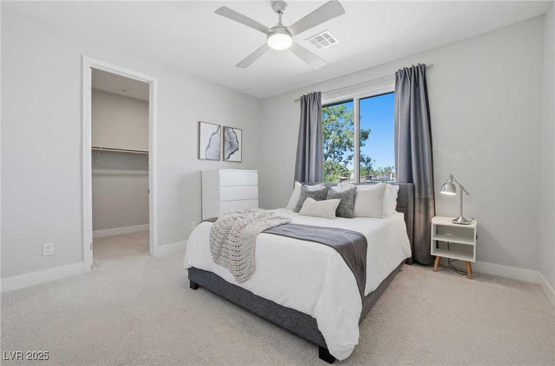 7736 Tioga Ridge Las Vegas, NV 89117 - Photo 27 of 68 Bedroom featuring a walk in closet, light colored carpet, and a ceiling fan