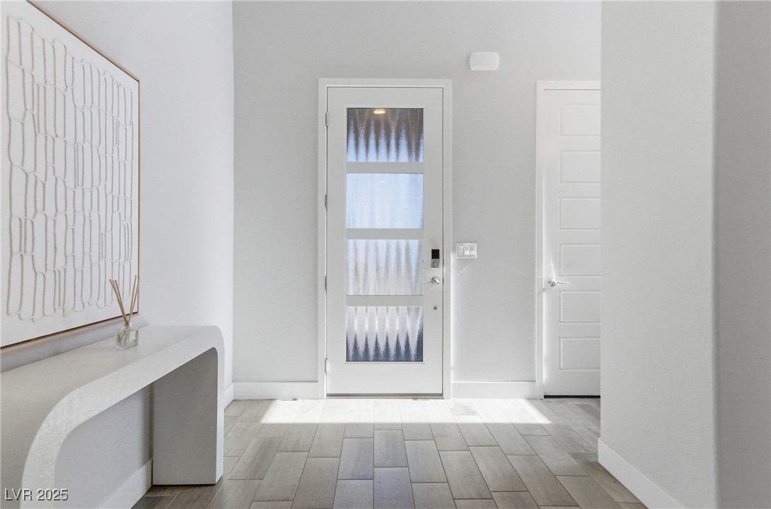7736 Tioga Ridge Las Vegas, NV 89117 - Photo 3 of 68 Foyer entrance featuring baseboards and wood tiled floors