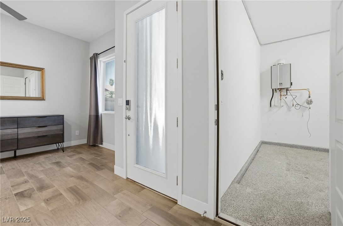 7736 Tioga Ridge Las Vegas, NV 89117 - Photo 52 of 68 Corridor with light wood-style floors and water heater