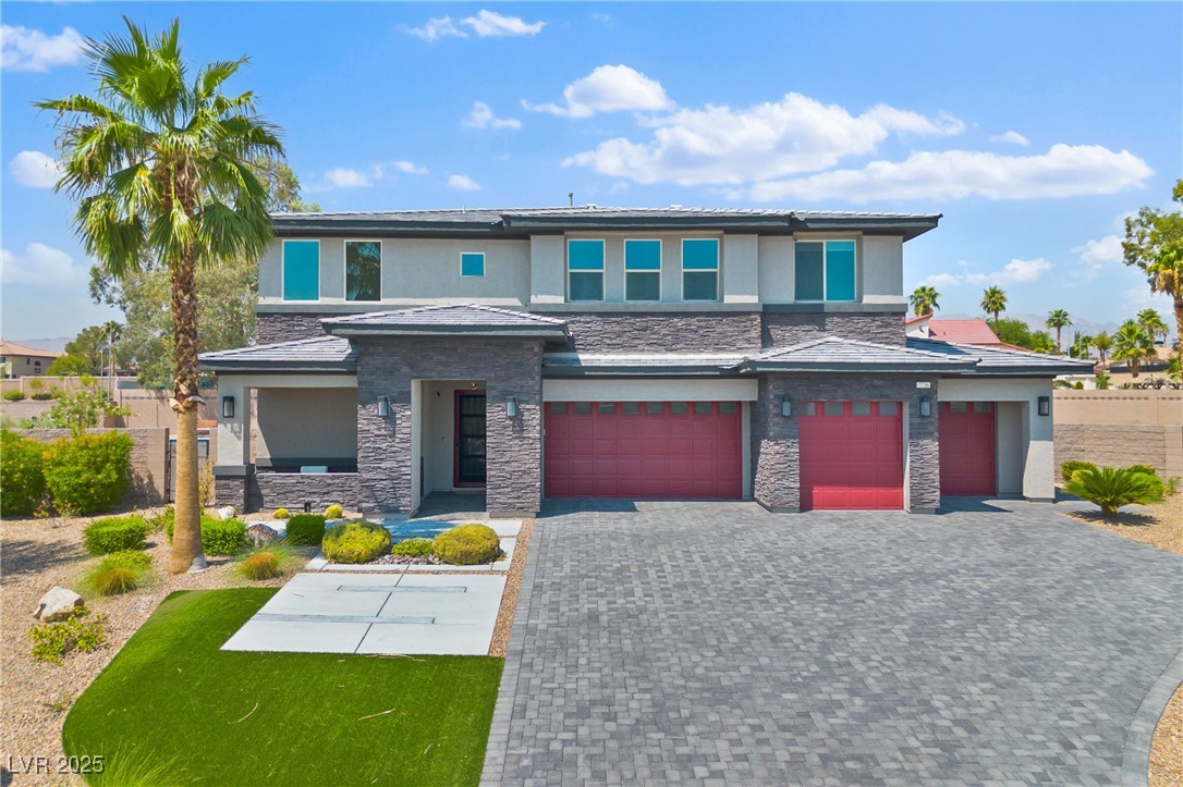 7736 Tioga Ridge Las Vegas, NV 89117 - Photo 66 of 68 Prairie-style house featuring stone siding, stucco siding, decorative driveway, and a garage
