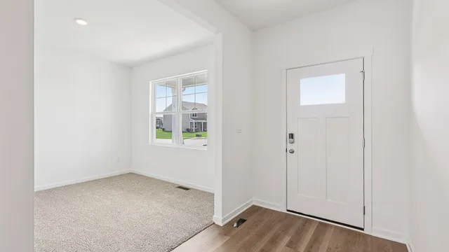an empty room with a window and wooden floor
