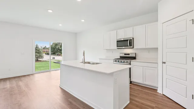a kitchen with kitchen island white cabinets and refrigerator