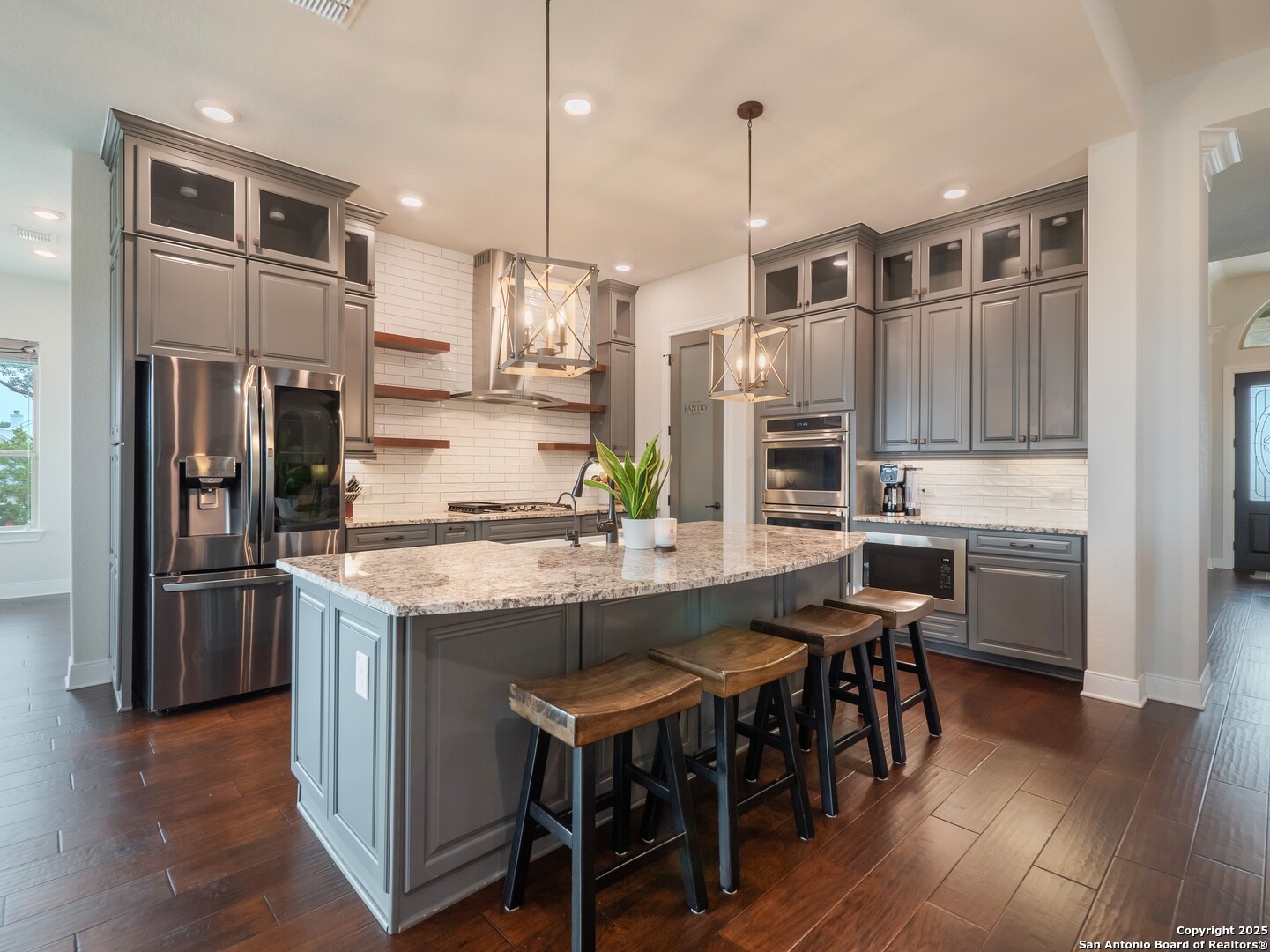 632 Carson Ridge New Braunfels, TX 78132 - Photo 13 of 57 a kitchen with stainless steel appliances granite countertop a table chairs stove and refrigerator