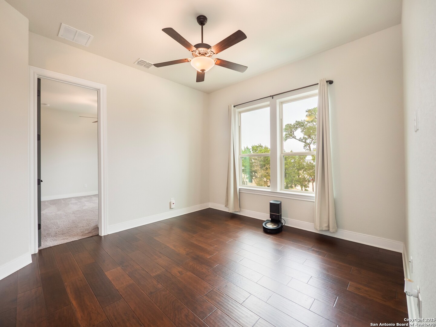 632 Carson Ridge New Braunfels, TX 78132 - Photo 29 of 57 an empty room with wooden floor a ceiling fan and windows