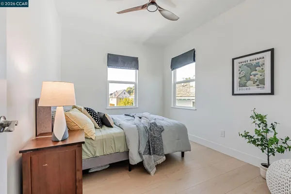 a bedroom with a bed and a lamp on dresser