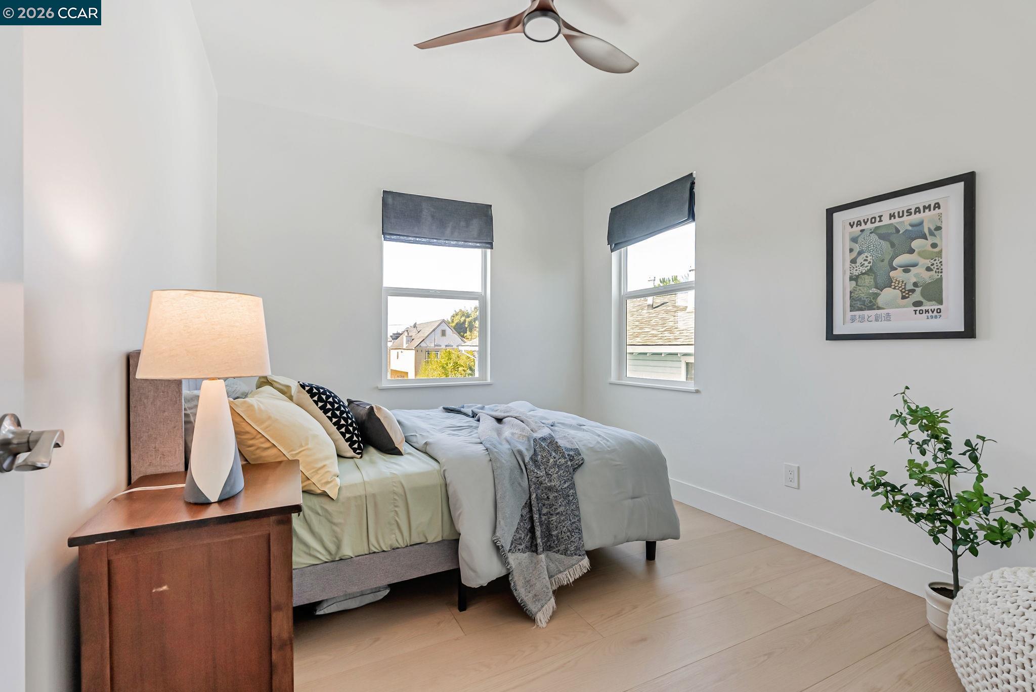 1727 9th Street Oakland, CA 94607 - Photo 18 of 36 a bedroom with a bed and a lamp on dresser