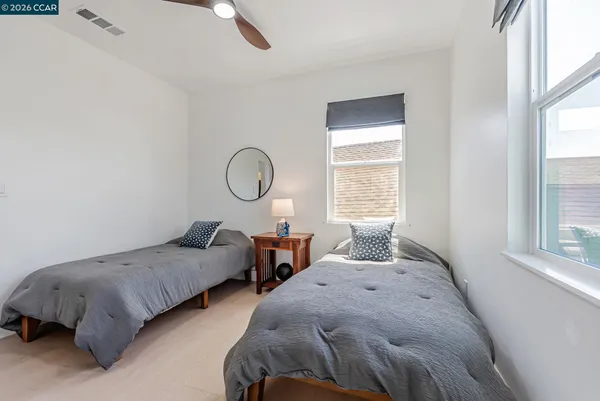 a bedroom with two beds and windows