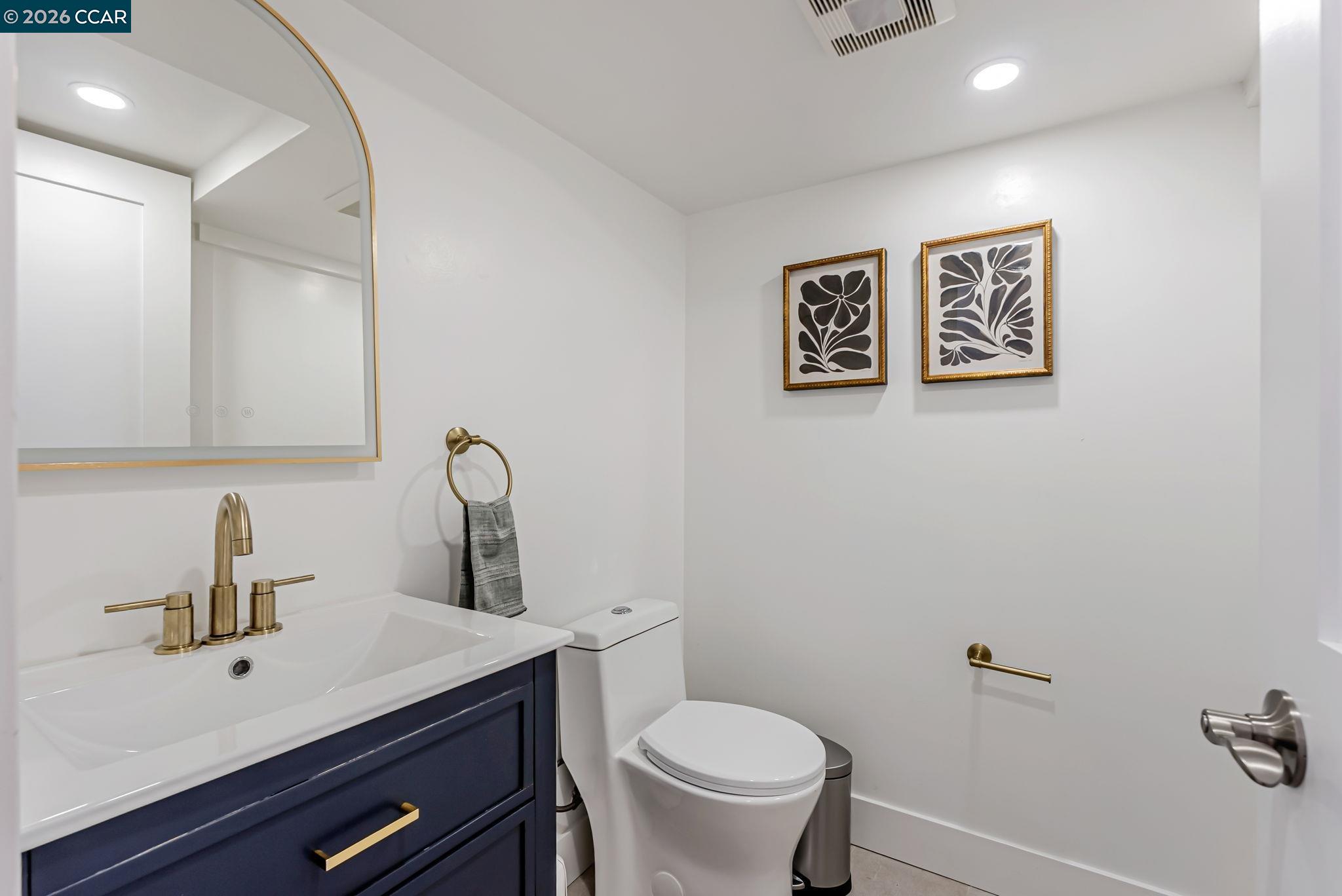 1727 9th Street Oakland, CA 94607 - Photo 27 of 36 a bathroom with a toilet a sink and mirror