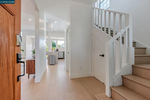 a view of a hallway with wooden floor and staircase