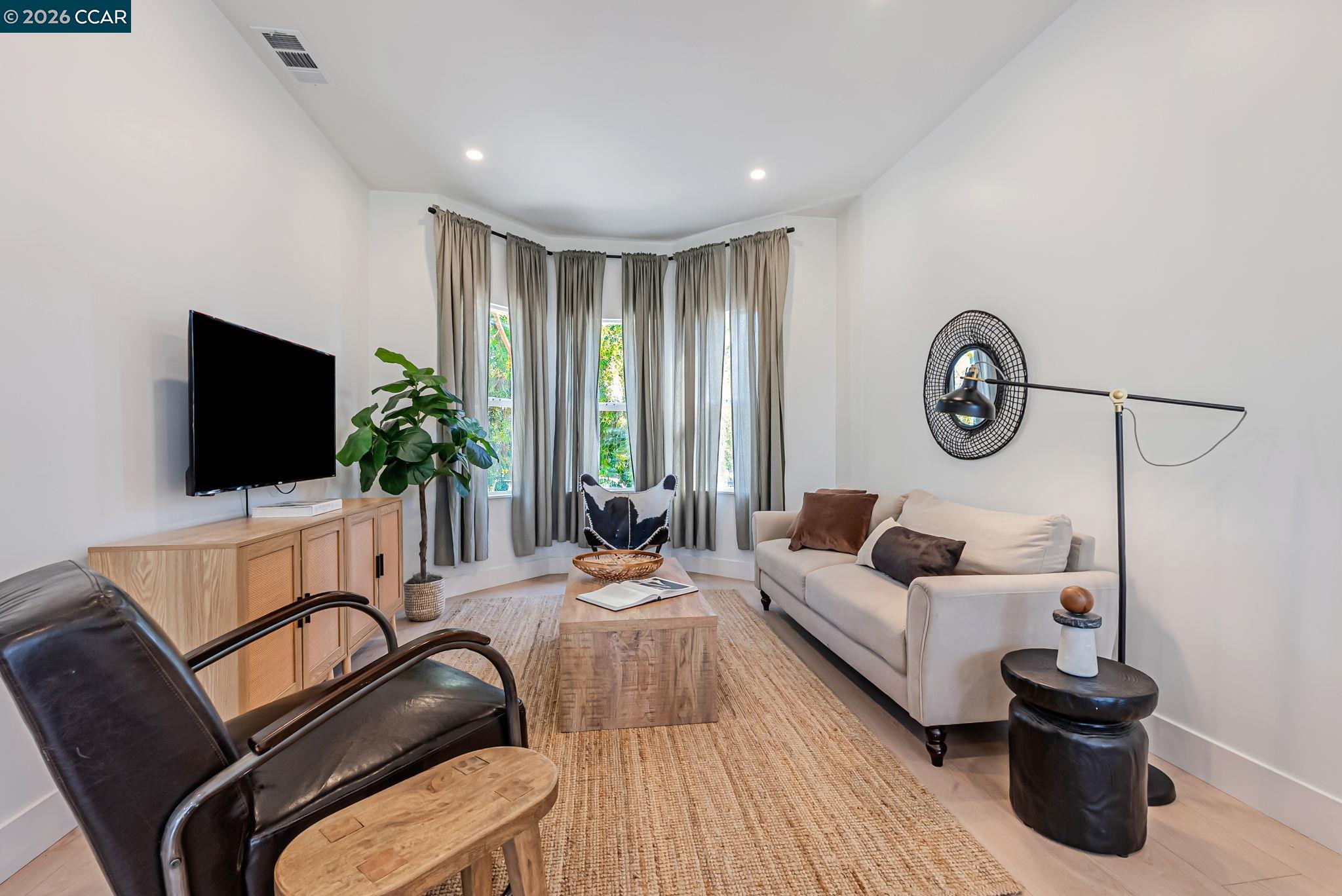 1727 9th Street Oakland, CA 94607 - Photo 6 of 36 a living room with furniture and a flat screen tv