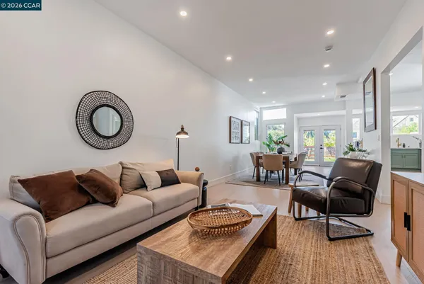 a living room with furniture a rug and a floor to ceiling window