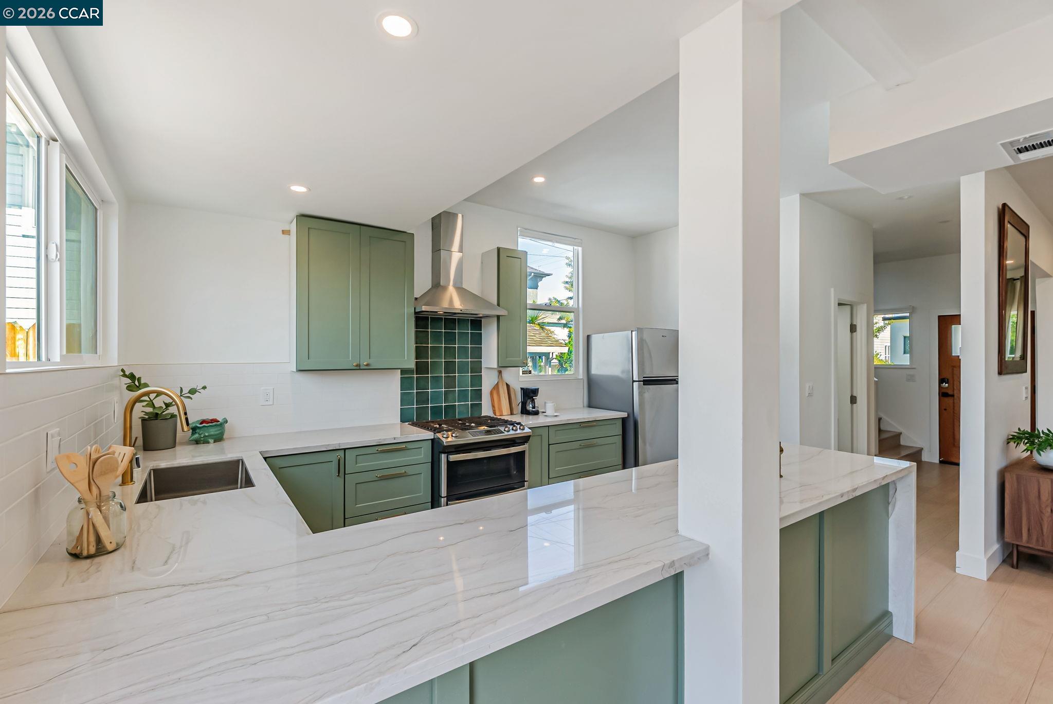 1727 9th Street Oakland, CA 94607 - Photo 10 of 36 a kitchen with stainless steel appliances kitchen island granite countertop a refrigerator and stove