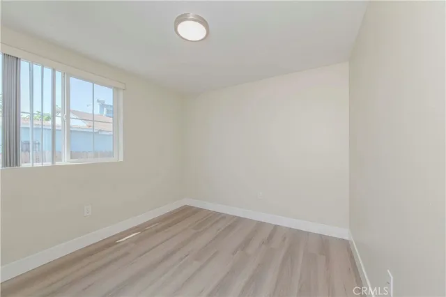a view of a room that has wooden floor and large window