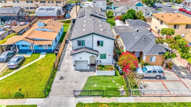 an aerial view of a house with swimming pool and large trees