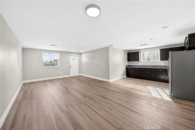 a view of empty room with wooden floor and window
