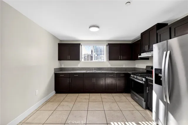 a kitchen with stainless steel appliances granite countertop a refrigerator and a stove