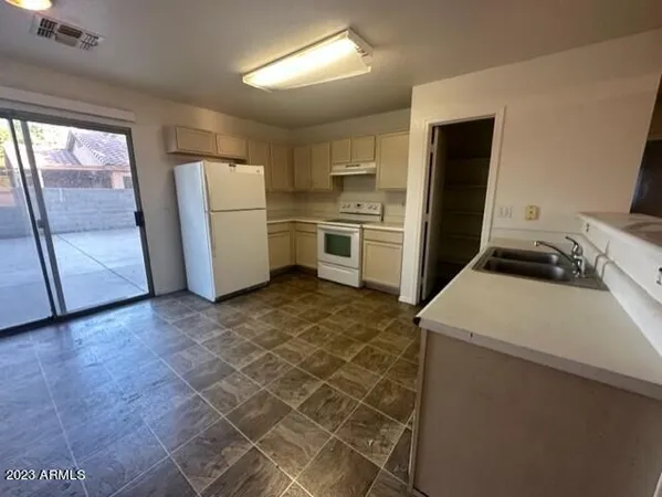a kitchen with a refrigerator sink and cabinets