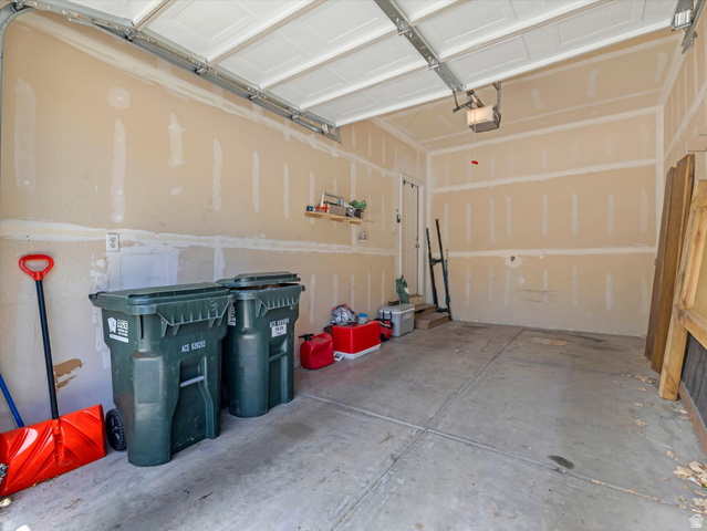 5038 West Red Shale Road Herriman, UT 84096 - Photo 16 of 16 Attached garage featuring an overhead door, concrete flooring, and a side entry door