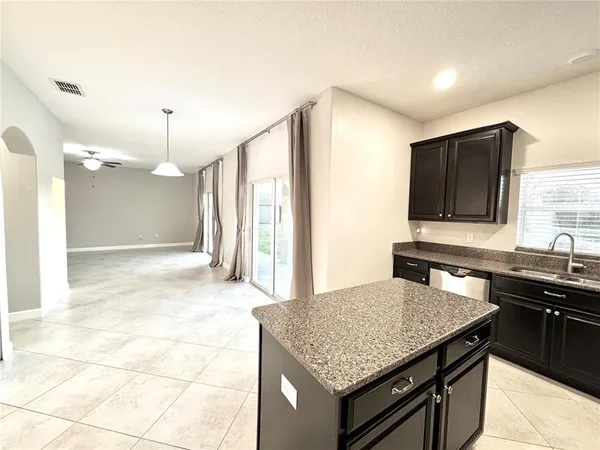 a kitchen with granite countertop a sink cabinets and stainless steel appliances
