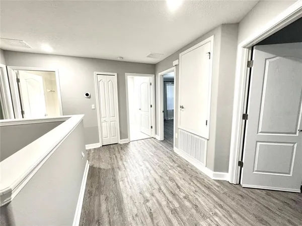 a view of a hallway with wooden floor and staircase