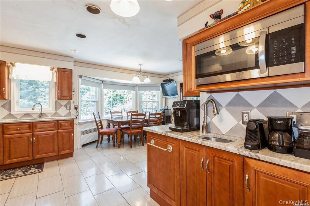 77 Duck Pond Road Glen Cove, NY 11542 - Photo 17 of 35 a kitchen with stainless steel appliances granite countertop sink stove and microwave
