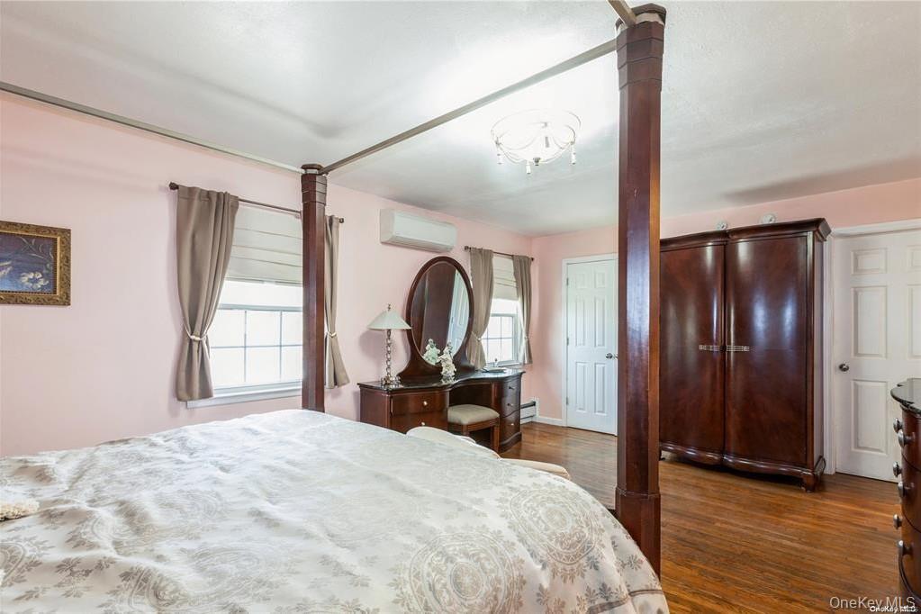 77 Duck Pond Road Glen Cove, NY 11542 - Photo 20 of 35 a bedroom with a bed and a large window