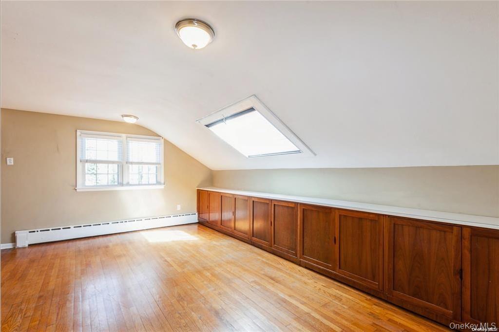 77 Duck Pond Road Glen Cove, NY 11542 - Photo 26 of 35 an empty room with wooden floor and windows