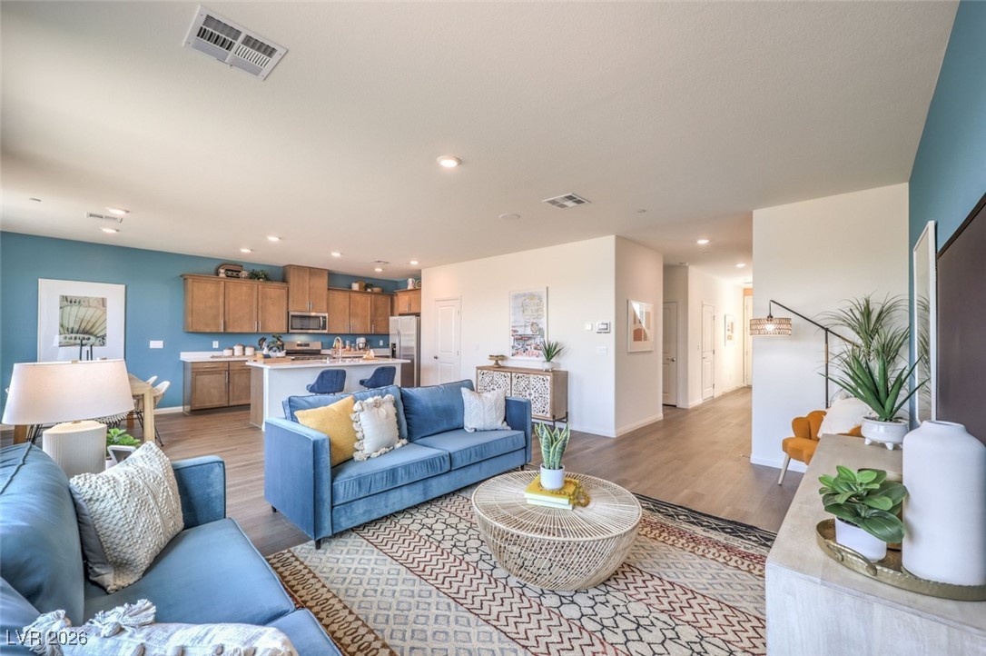 1001 Copper Robin Street, Unit 735 Henderson, NV 89011 - Photo 3 of 17 Living room featuring baseboards, visible vents, recessed lighting, and light wood finished .Photos are of a model home and are for representational purposes only.